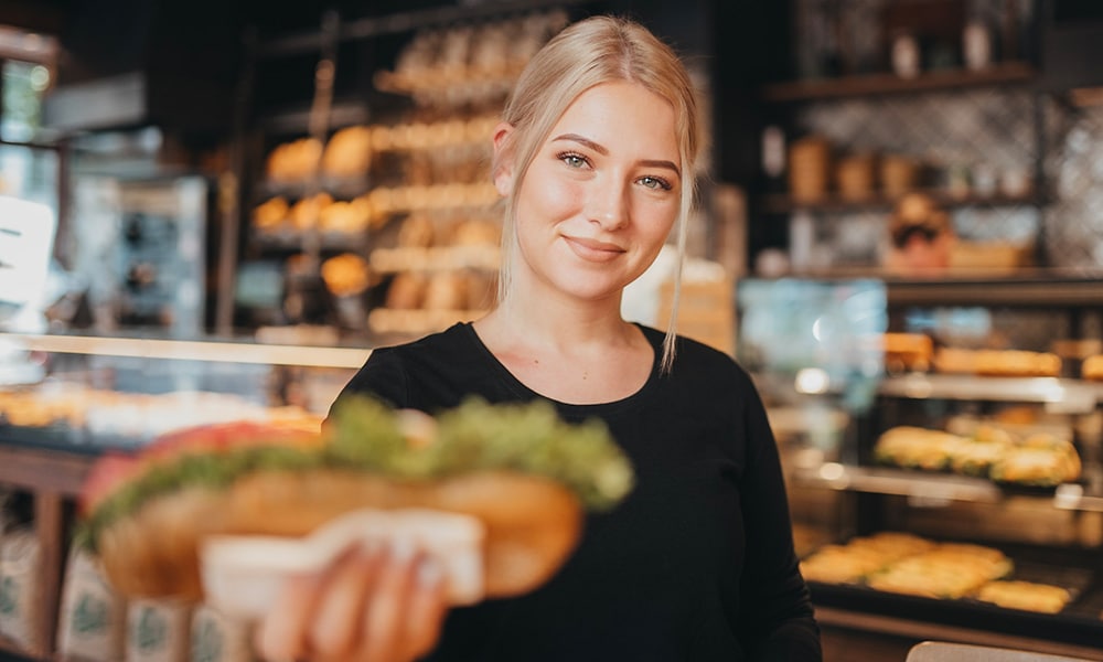 Auszubildende Verkäuferin der Bäckerei Schnell bei der Arbeit in der Filiale in Berlin